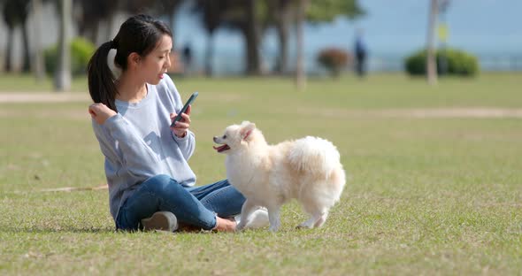 Asian Woman playing with her dog at outdoor park