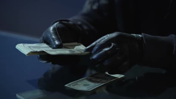 Criminal in Black Gloves Counting Bundle of Money Earned for Committing Crime