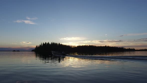 Boat sailing on lake at sunset