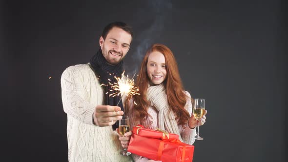 Happy Young Family Holding Champagne Glasses and Sparklers for New Year