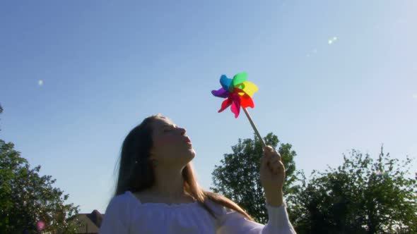 Female blowing on a pinwheel