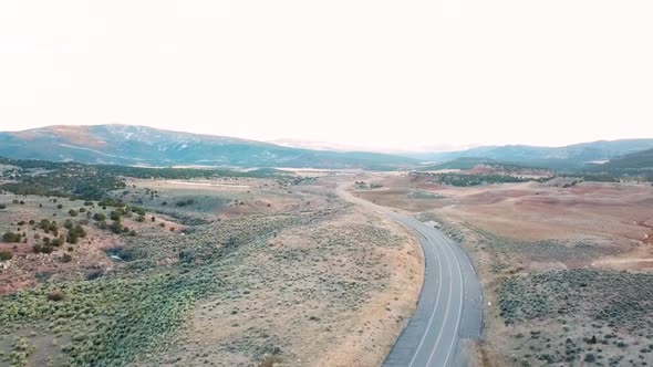 Flying over empty desert mountain road