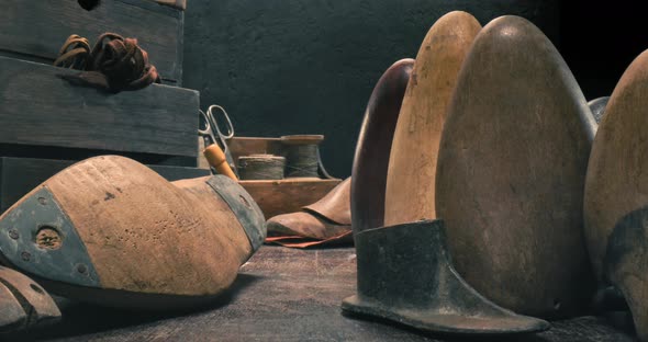 Old cobbler workplace with tools, laces and shoes.