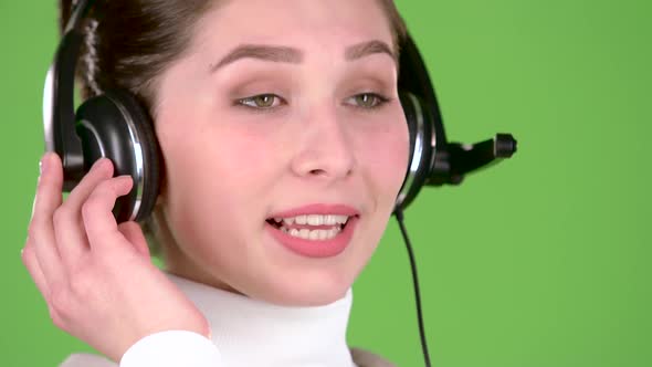 Support Worker Speaks To Customers on the Headset. Green Screen. Close Up