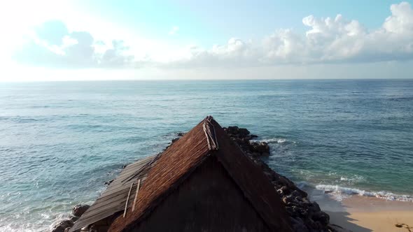 Drone Flying Over Beachhouse and Breakwater Ocean