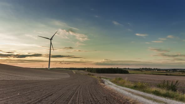 Beautiful sunset over a field with a windmill in autumn, timelapse, 4K