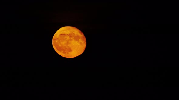 A Full Moon is Floating Against Black Sky