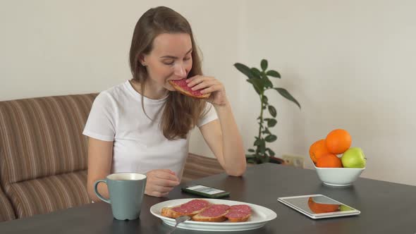 Woman Using a Smartphone at Home in a Modern Kitchen