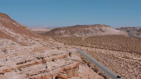 Car driving on a road through Red Rock Canyon in California Mojave Desert, AERIAL