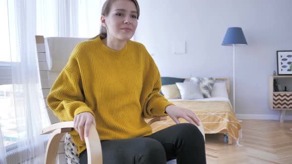 Young Woman Leaving Relaxing Chair in Bedroom