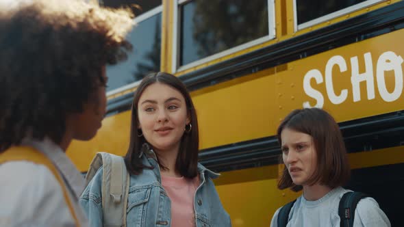 Three School Girls Standing at Yellow Bus