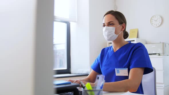 Doctor or Nurse in Mask with Computer at Hospital