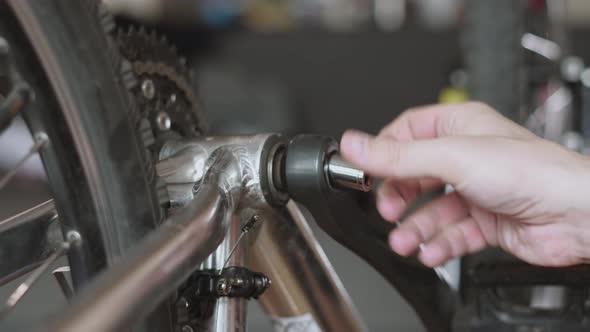 Unscrew Metal Bolt From Bicycle Connecting Rod with Socket Wrench Closeup