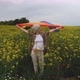 Lesbian woman with LGBT flag on a field with yellow flowers, LGBT flag waving in the wind - VideoHive Item for Sale