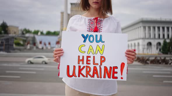 Woman in Embroidery Holds Patriotic Poster Standing in Kyiv