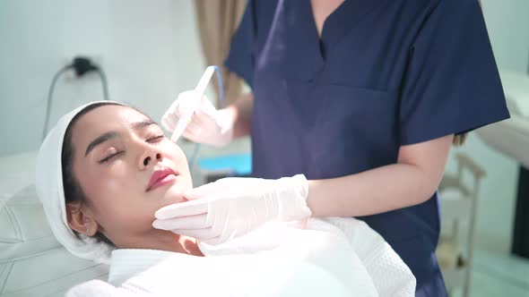 professional woman doctor doing a laser treatment on beauty rejuvenation care on face skin