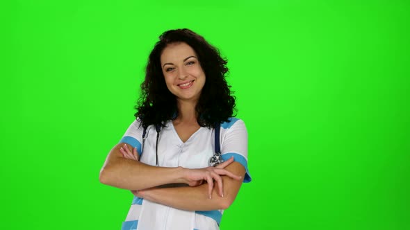 Smiling Beautiful Nurse Standing in a White Coat with Stethoscope Around His Neck