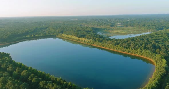 Panoramic Top View of Clouds of Fog Over Lake Near the Green Forest