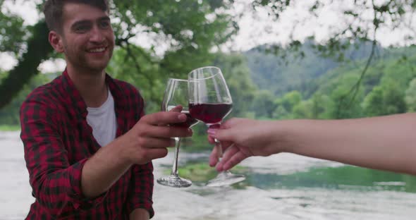 Happy Couple Preparing Barbecue and Drinking Red Wine Outdoor Near River