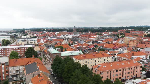 Colorful city of Ystad with red rooftops and church tower, aerial drone view