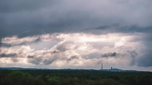 Gray Cumulus Clouds Moves Over the Horizon and an Industrial Plant Timelapse