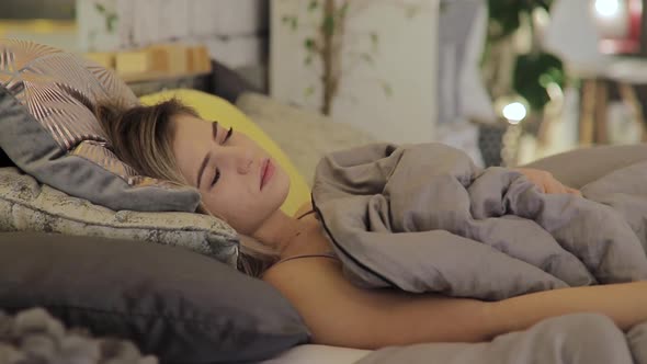 Young Woman Sad with Strong Headache Wakes Up in the Morning