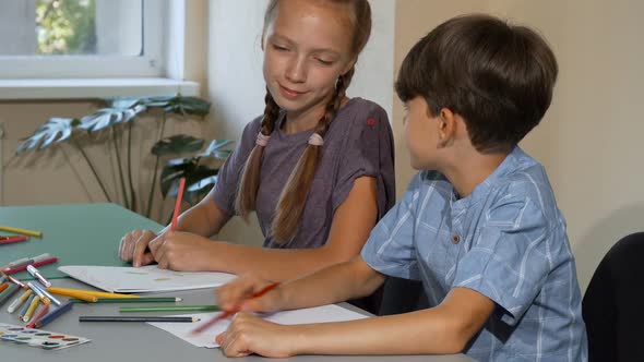 Two Kids Enjoying Talking and Drawing at Art Class Together