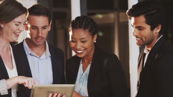 Group of businesspeople discussing together over digital tablet