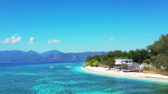 Luxury aerial tourism shot of a sandy white paradise beach and blue water background in colourful 4K