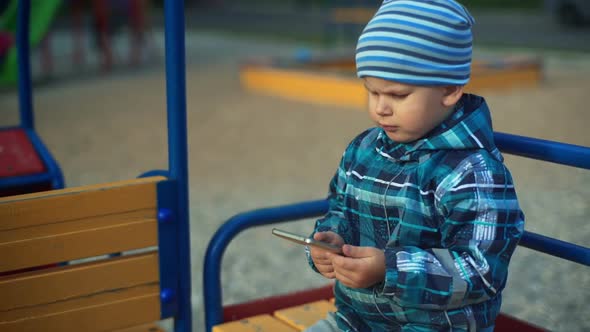 Child Playing with Smart Phone in the Park