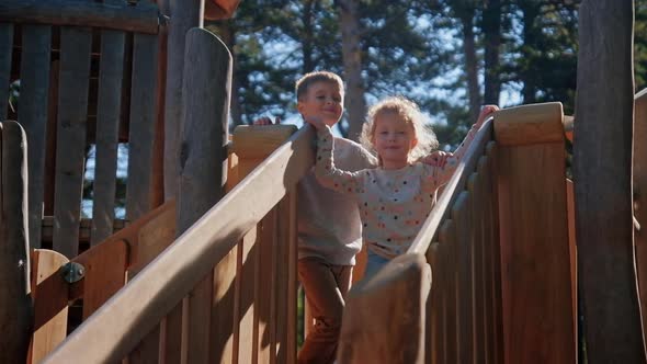 Children Hugs at Country Playground Wooden Slide alt