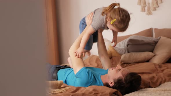 Dad and Daughter Play in Bedroom Happy Family on Bed