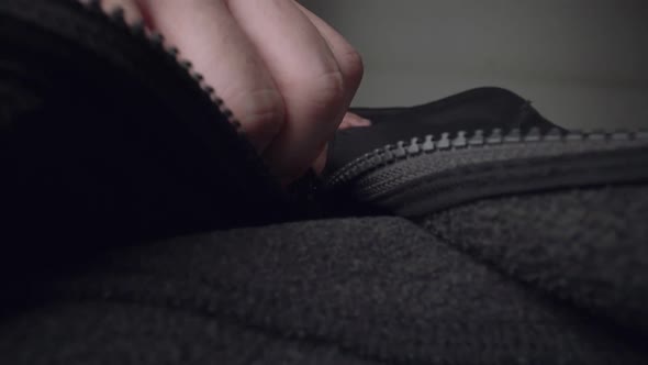Extreme Close Up Zipper with Hand Unzipping the Sweater Jacket Zipper