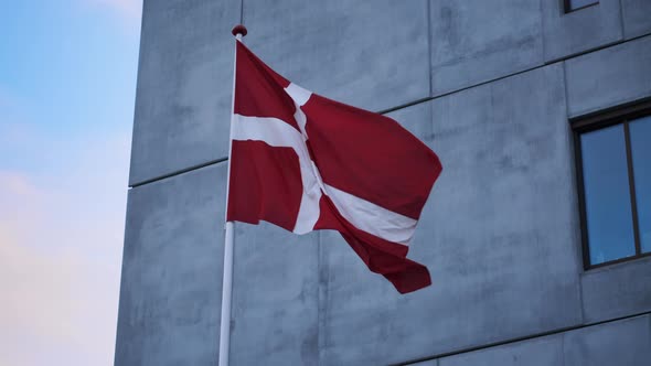 Danish Flag Blowing In Wind Outside Building