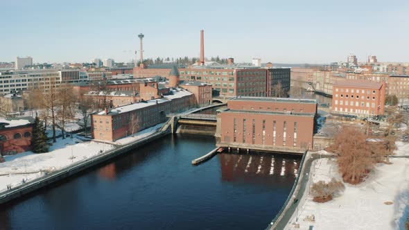 ascending drone footage of the rapids and dam in the city center of Tampere