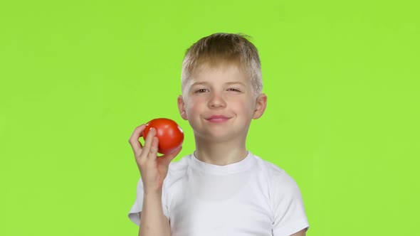Small Boy Holding a Tomato Sniffs It, and Shows a Thumbs Up. Green Screen