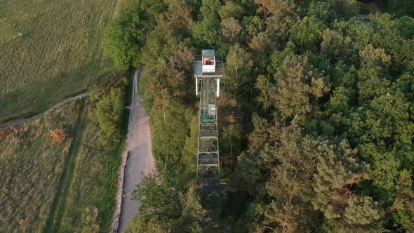 Steel forest side watchtower in orbit aerial drone view