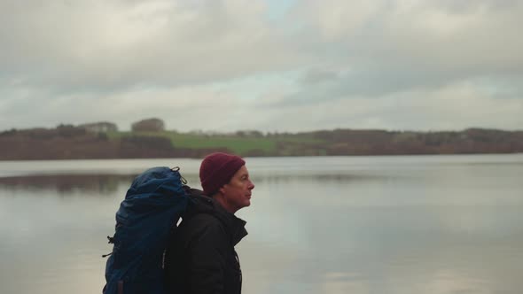 Tourist with Huge Backpack Walks Along the Lake in Himmelbjerget Area Denmark