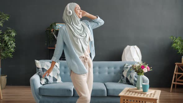 Slow Motion Portrait of Pretty Muslim Lady Wearing Headphones Dancing Indoors at Home