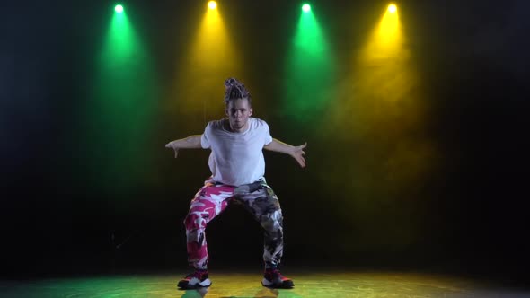 Professional Young Hip-hop Dancer, Dancing in Dark Studio in the Green and Yellow Fog. Hip Hop