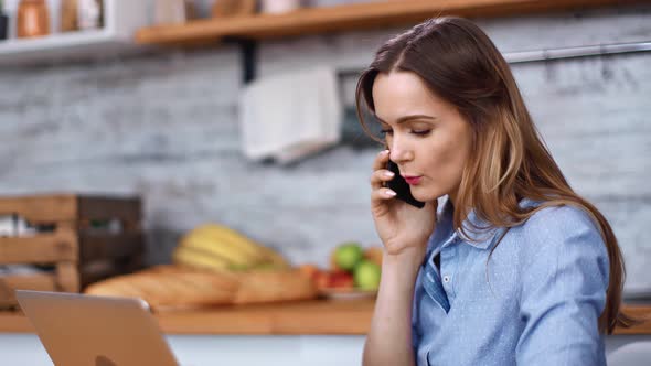 Happy Freelancer Woman Talking Smartphone Looking at Laptop