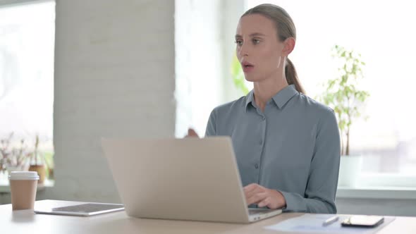 Woman Coughing While Using Laptop in Office