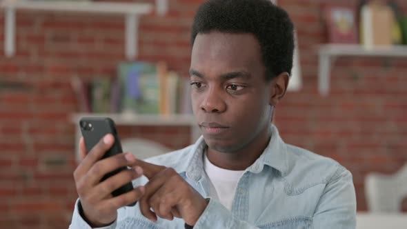 African Male Using Smartphone, Browsing Internet