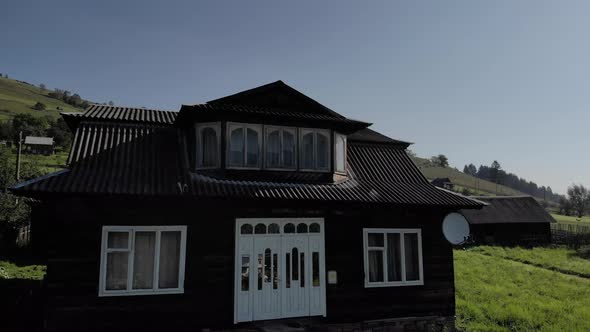 Wooden House on Green Meadow in Mountains