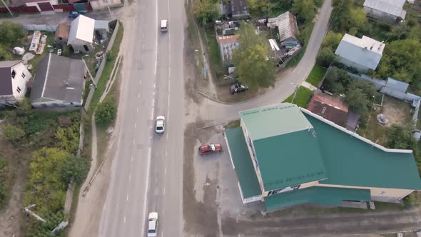 Aerial View of a City Street with Moving Cars and Onestory Houses