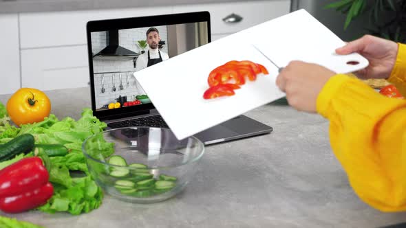 Woman in Kitchen Knives Sliced Bell Pepper From Cutting Board Into Salad Bowl