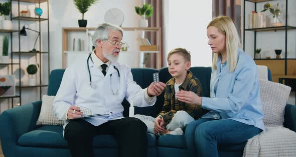 Doctor Giving Pills to Attantive Blond Woman and Her Son and Explaining About Rules