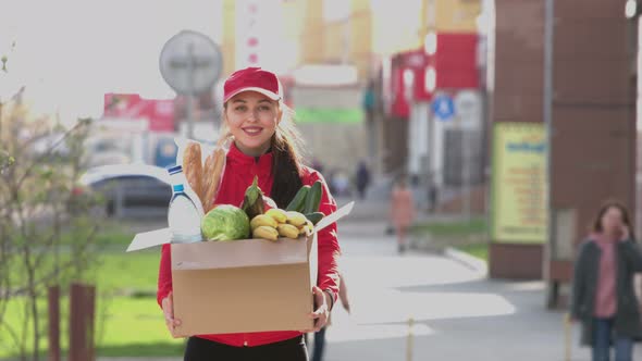 Courier girl with box of food on street