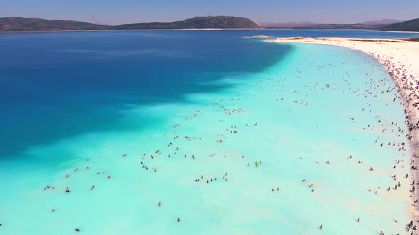 People Swim on Vacation in the White Sandy Beach of the Clear Tropical Turquoise Light Blue Sea