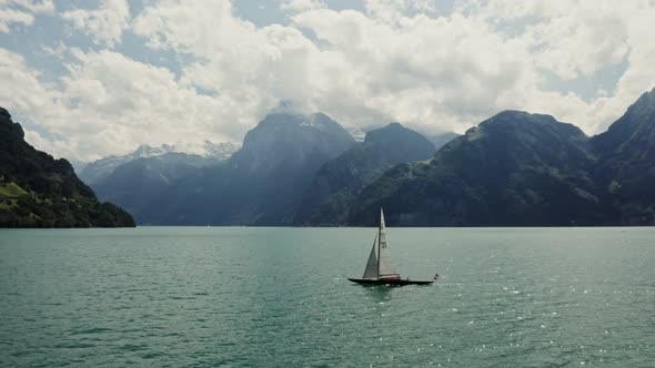 A Sailboat Floats on a Picturesque Lake at the Foot of the Alpine Mountains